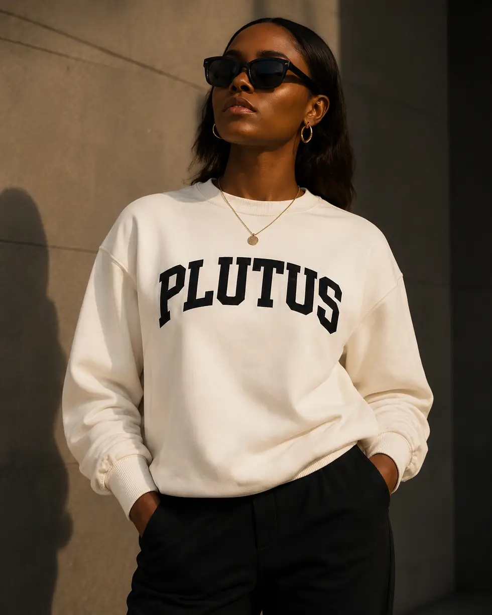 A woman wearing the bone PLUTUS crewneck against a concrete wall.